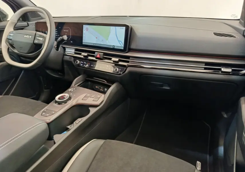 Intérieur du Kia Sportage 2026 vu côté passager, tableau de bord noir avec écran tactile large et volant clair.