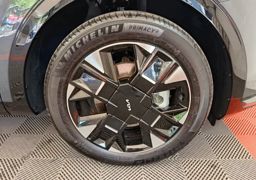 Gros plan sur la roue avant droite gris foncé du KIA SPORTAGE 2026 avec jante noire et argentée au design géométrique.