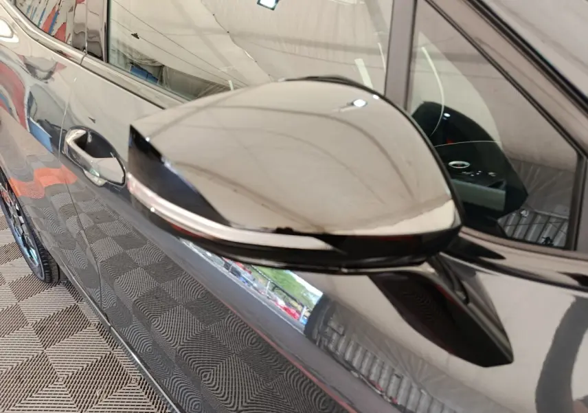 Rétroviseur côté gauche gris foncé du Kia Sportage 2026, avec clignotant intégré et carrosserie brillante.