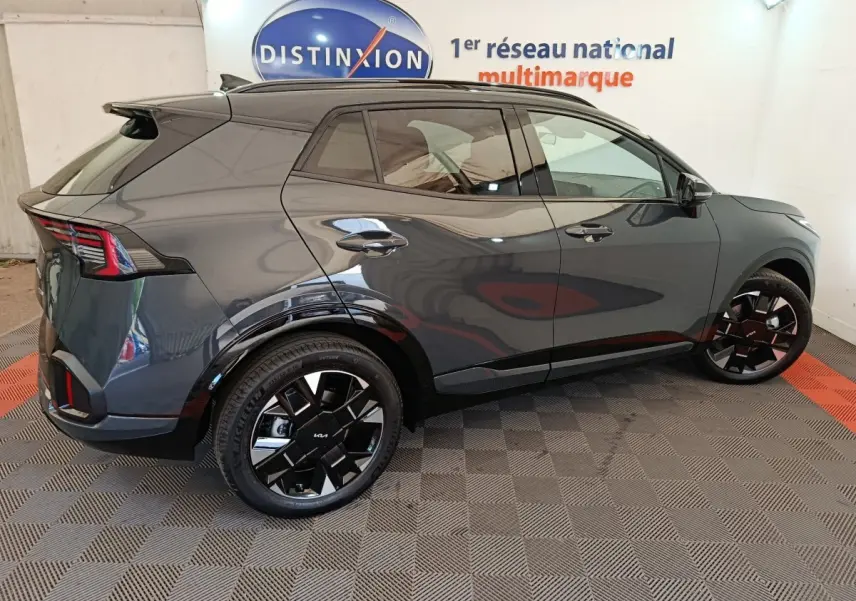 KIA Sportage gris foncé vu de profil droit, avec jantes noires et feux arrière LED distinctifs.
