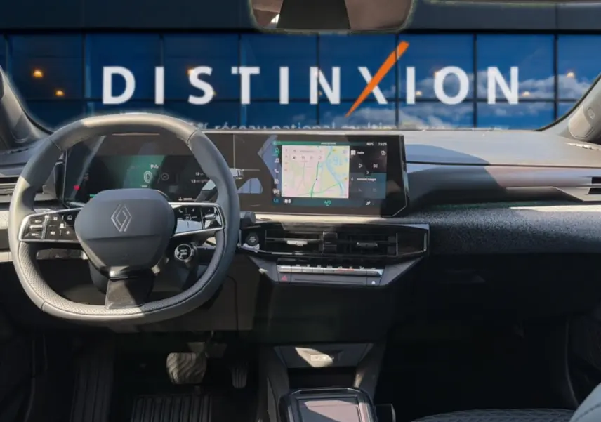 Vue intérieure avant de la Renault Clio VI noire, avec tableau de bord numérique et écran tactile central affichant la navigation.
