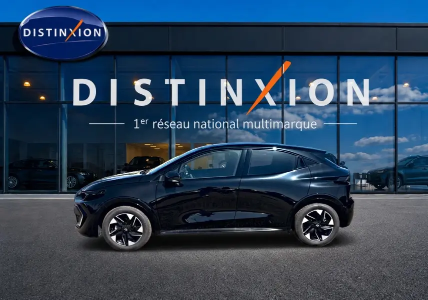 Renault Clio VI noire vue de profil côté gauche, avec jantes alliage et silhouette compacte devant une vitrine Distinxion.