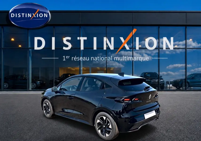 Vue 3/4 arrière droite d'une Renault Clio VI noire stationnée devant une vitrine avec logo Distinxion.