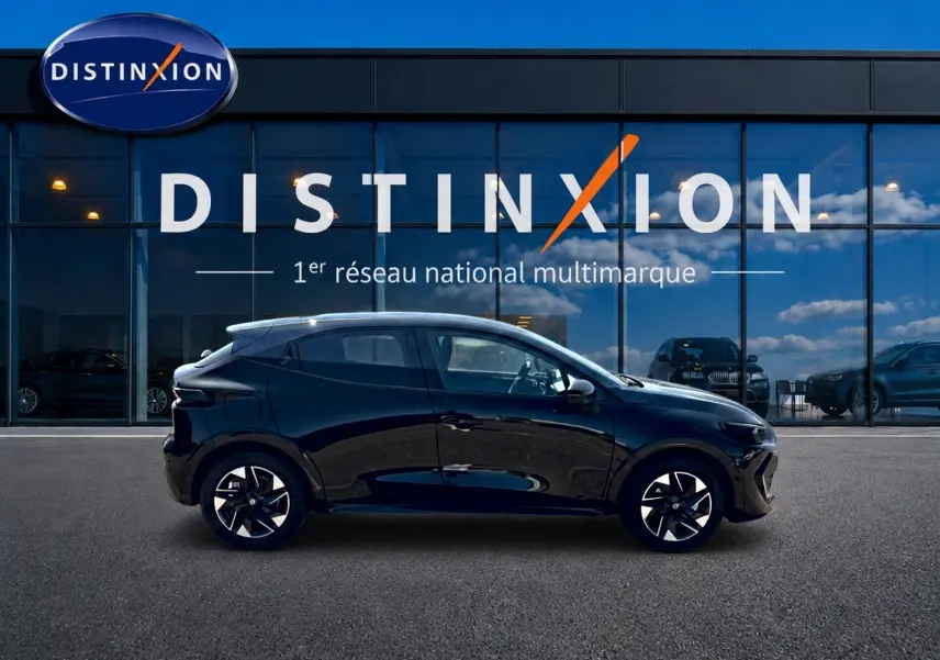 Profil côté gauche d'une Renault Clio VI noire 2026 avec jantes alliage, devant une vitrine Distinxion.