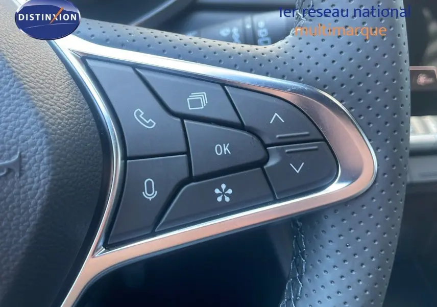 Gros plan sur les commandes multifonctions du volant en cuir perforé du Renault Captur E-Tech hybride noir étoile métal 2025.