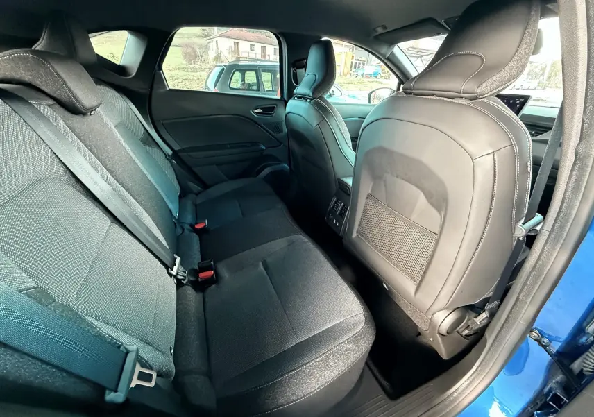 Vue intérieure arrière côté droit du Renault Captur 2025 bleu Iron Metal, sièges tissu noir et dossier avant en cuir.