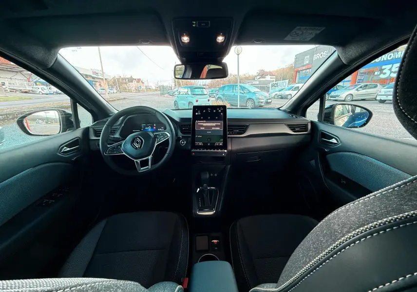Intérieur du Renault Captur E-Tech hybride 2025 vu de l'arrière, avec tableau de bord moderne et écran tactile vertical.