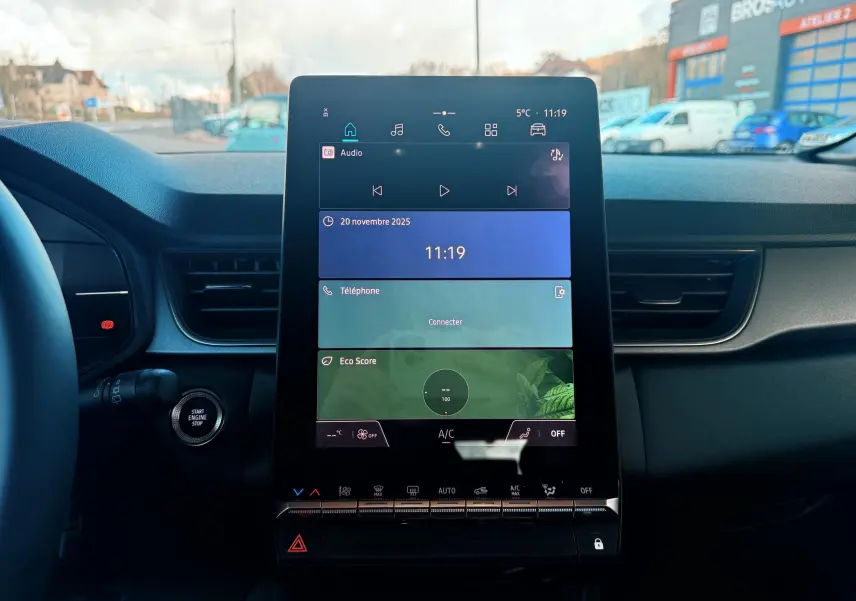 Vue intérieure du tableau de bord du Renault Captur 2025, écran tactile central affichant audio, téléphone et Eco Score.