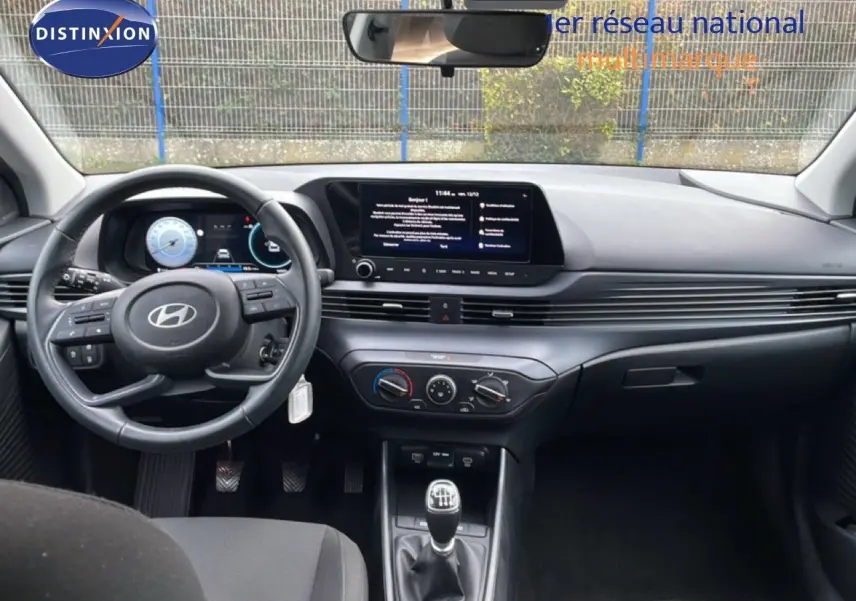 Vue intérieure avant de la Hyundai i20 2025 noir Phantom Metal, tableau de bord moderne avec écran tactile et boîte manuelle.