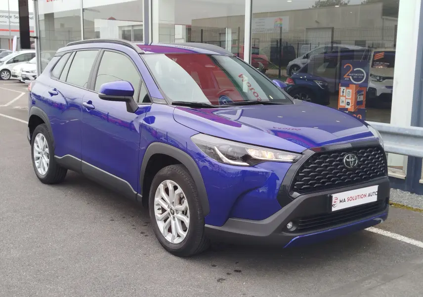 Toyota Corolla Cross bleu cosmique vue en 3/4 avant droit, avec calandre noire et jantes alliage argentées.