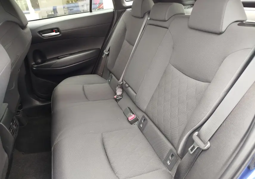 Vue intérieure de la banquette arrière grise du Toyota Corolla Cross 2024, côté droit avec ceinture de sécurité visible.