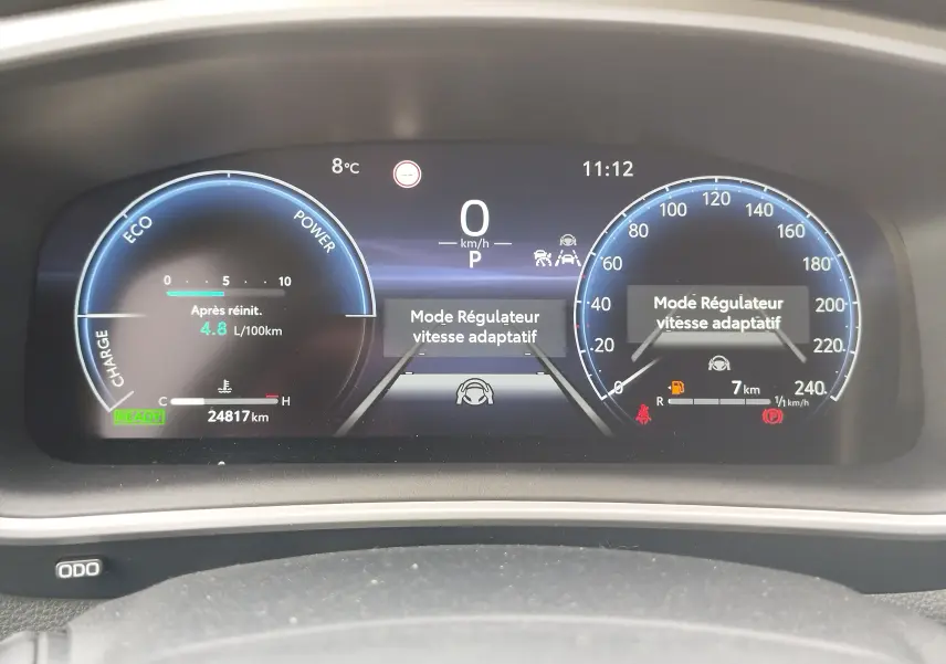 Tableau de bord numérique de Toyota Corolla Cross 2024 affichant la consommation, la vitesse à 0 km/h et le mode régulateur adaptatif.