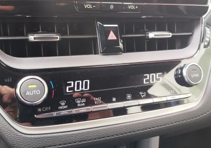 Détail du tableau de bord de la Toyota Corolla Cross 2024, affichage numérique de la climatisation avec réglages à 20°C.