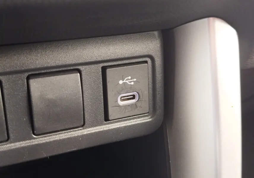 Gros plan sur un port USB-C intégré dans la console intérieure du Toyota Corolla Cross 2024 bleu cosmique.