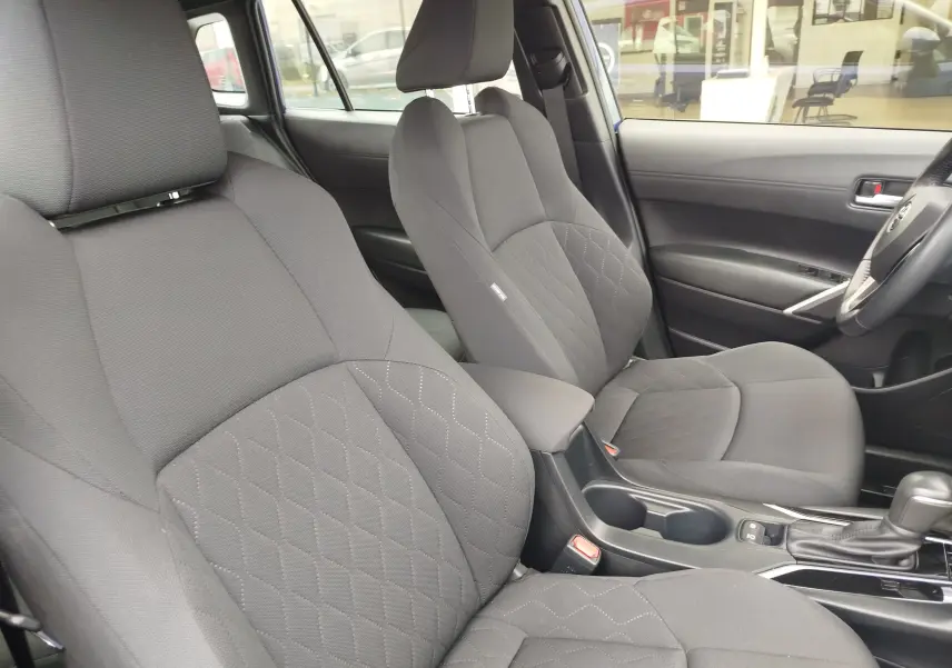 Vue intérieure côté droit des sièges avant gris foncé avec surpiqûres en losange du Toyota Corolla Cross 2024.