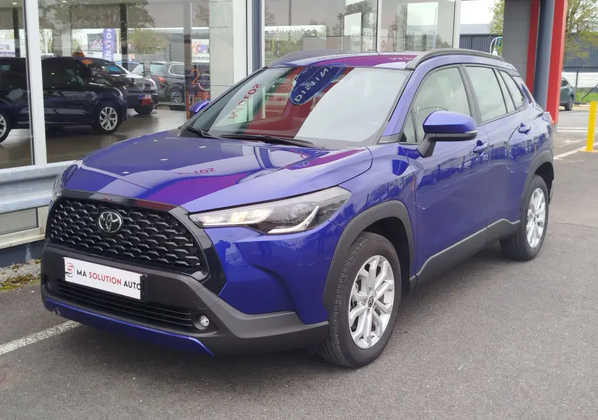 Toyota Corolla Cross bleu cosmique vue 3/4 avant droit, avec calandre noire et jantes argentées.