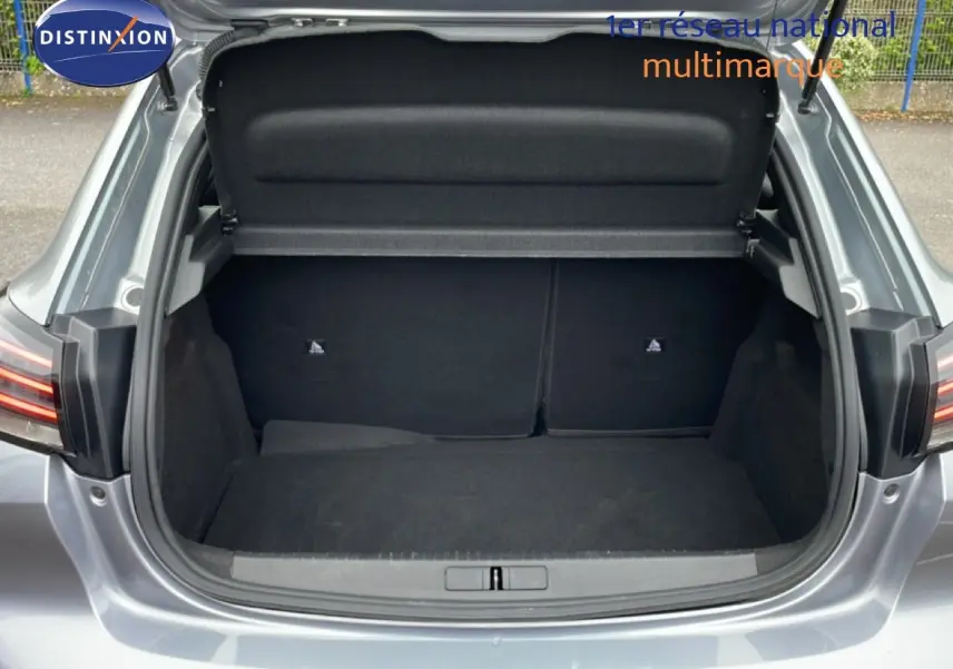 Coffre ouvert vu de l'arrière d'une Peugeot 208 gris Artense métal, montrant l'espace de chargement vide.