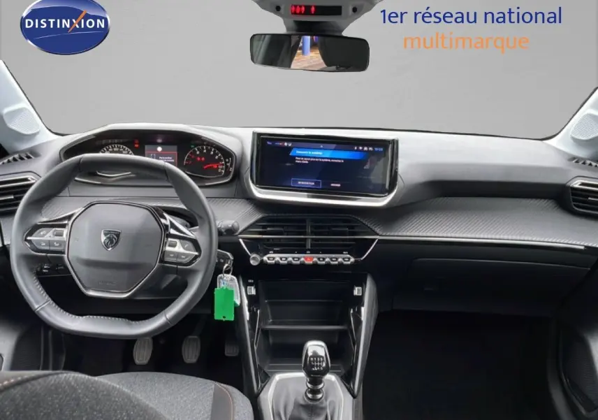 Vue intérieure avant de la Peugeot 208 1.2 100CH Style 2025, volant cuir multifonction et écran tactile central.