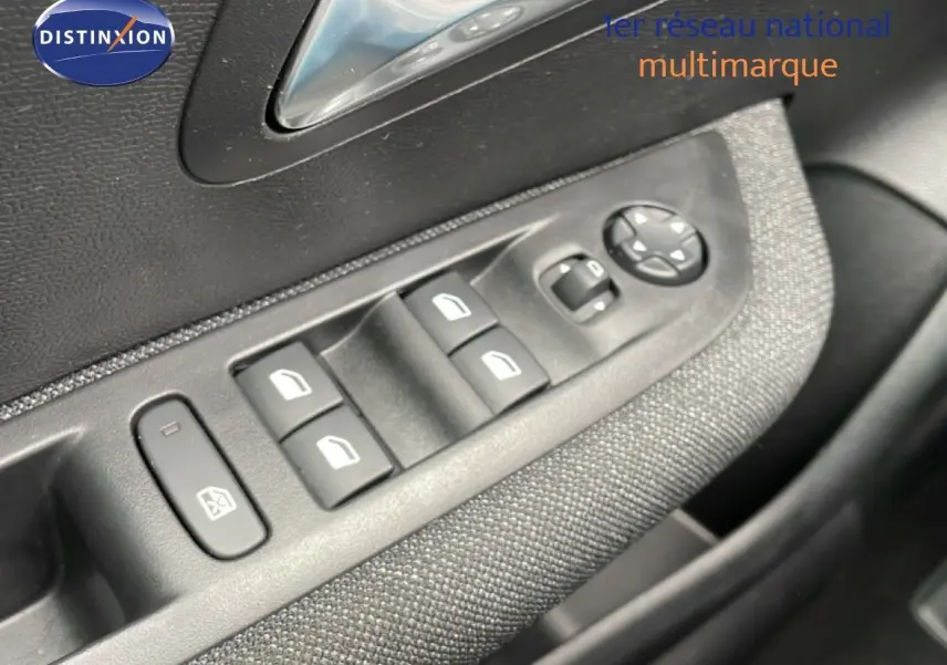 Détail des commandes des vitres électriques et rétroviseurs sur la porte côté conducteur d’une Peugeot 208 gris Artense.