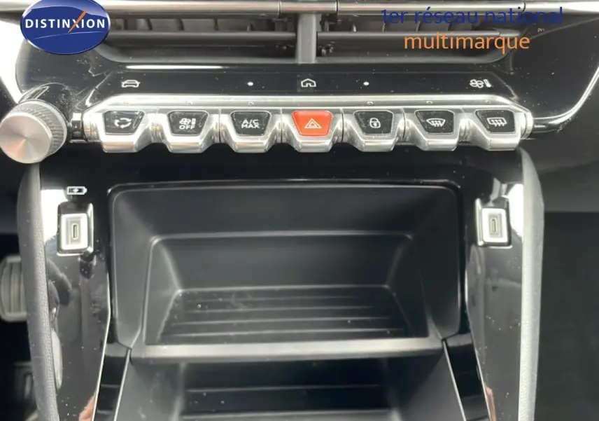 Vue rapprochée de la console centrale de la Peugeot 208 2025 gris Artense, avec boutons de commande et ports USB visibles.
