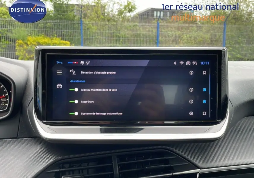 Écran tactile central du tableau de bord de la Peugeot 208 gris Artense, affichant les aides à la conduite.