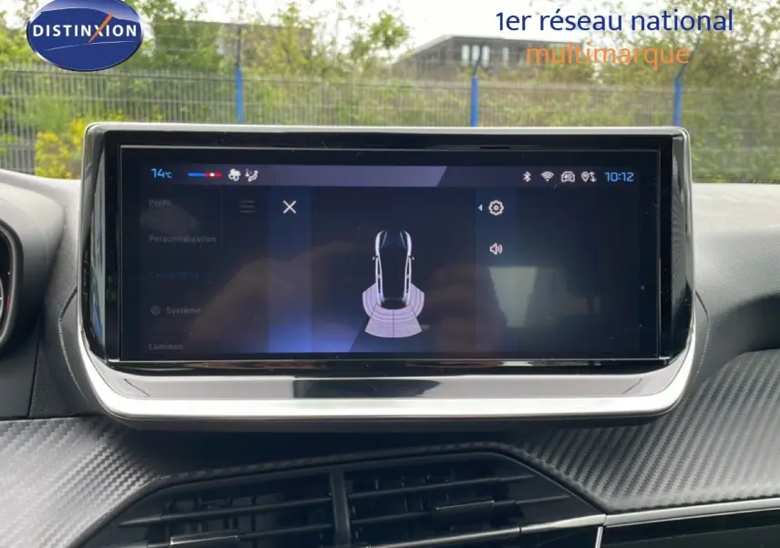 Écran tactile central affichant l'aide au stationnement dans l'habitacle d'une Peugeot 208 gris Artense.