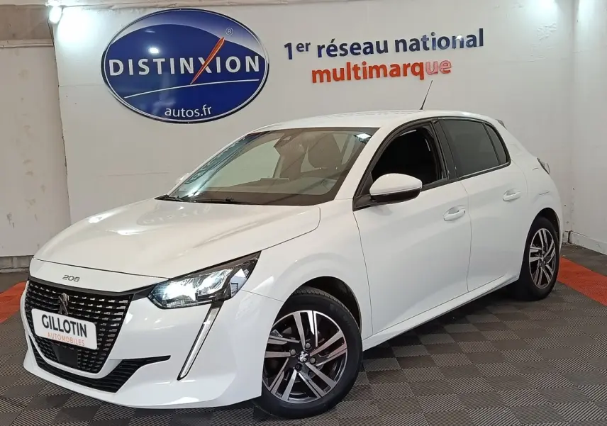 Peugeot 208 blanc vue 3/4 avant droit, avec phares LED allumés et jantes alliage distinctives.