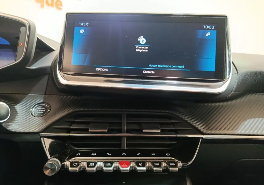 Vue rapprochée de l’écran tactile 10 pouces et de la console centrale noire à finition carbone du Peugeot 208 blanc.