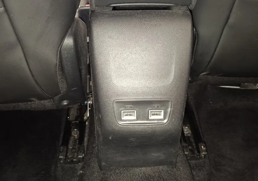 Vue rapprochée des ports USB arrière sur la console centrale noire d'une Peugeot 208 blanche de 2021.