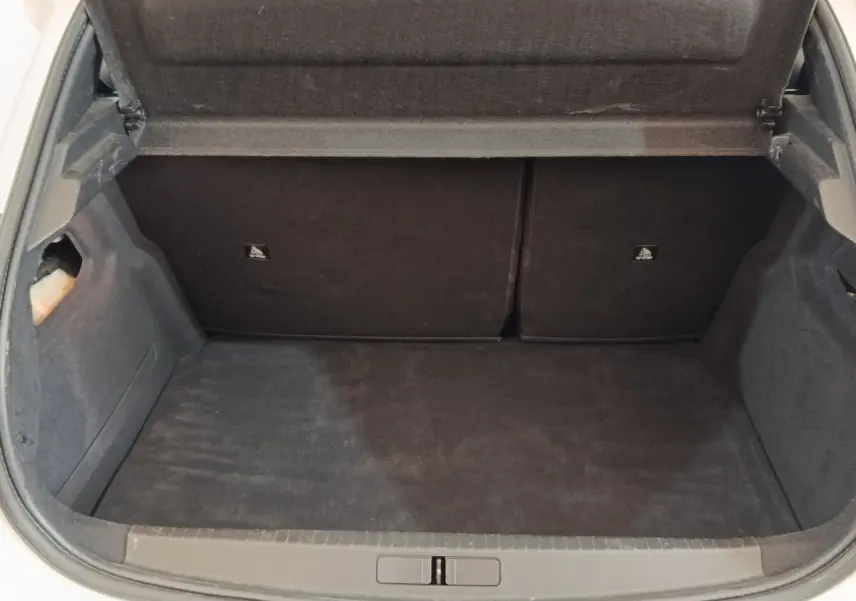Coffre ouvert de la Peugeot 208 blanc vue de l'arrière, montrant l'espace de chargement et la banquette rabattable.