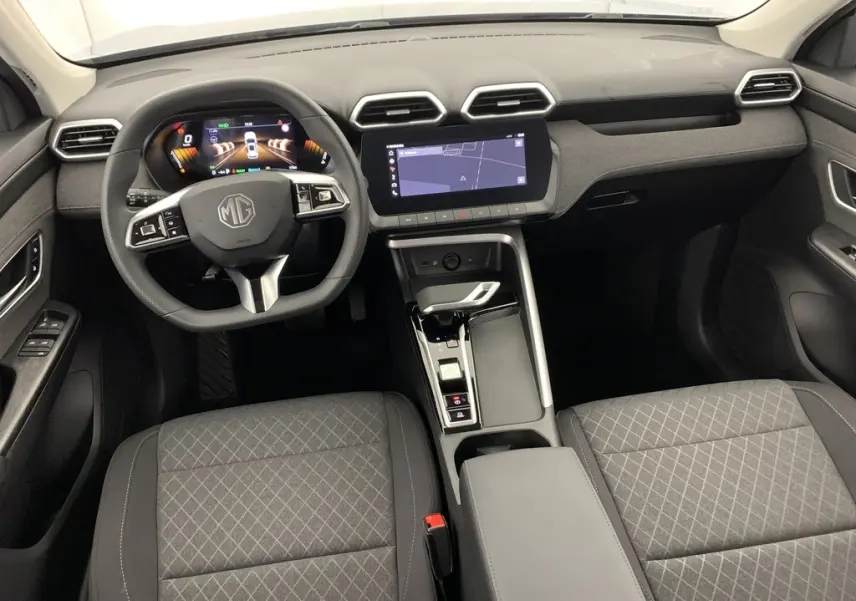 Vue intérieure avant du MG ZS 1.5 L Hybrid+ 2026, tableau de bord noir avec écran tactile 10,25'' et sièges tissu gris.