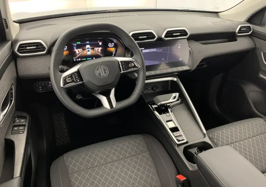 Vue intérieure avant du MG ZS 1.5 L Hybrid+ 2026 avec tableau de bord numérique et sièges tissu noir.