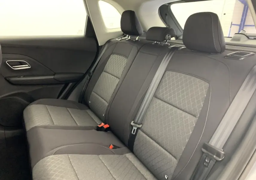 Vue intérieure arrière côté gauche des sièges en tissu noir et gris du MG ZS 1.5 L Hybrid+ 2026 avec ceintures de sécurité visibles.