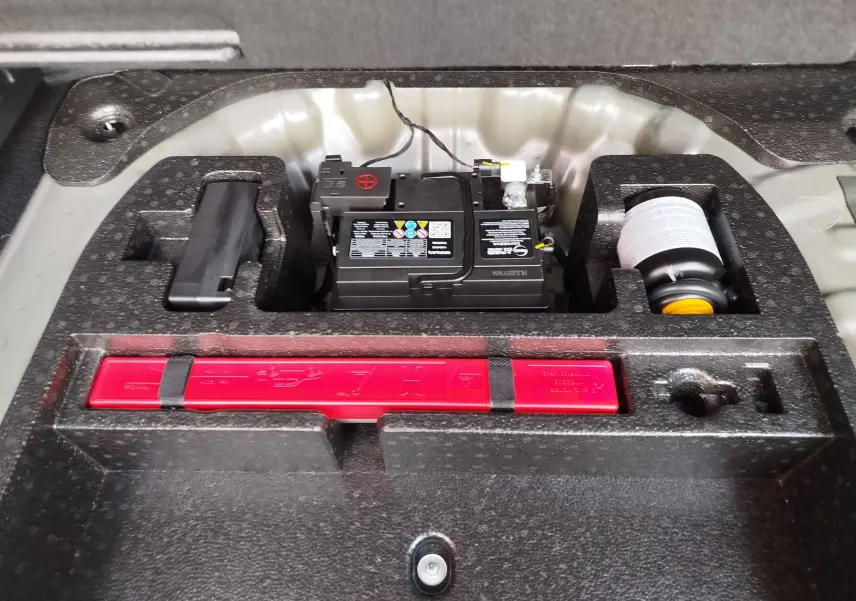 Gros plan sur le compartiment batterie et kit de secours du MG ZS 1.5 L Hybrid+ 2026 en couleur Hampstead Grey.