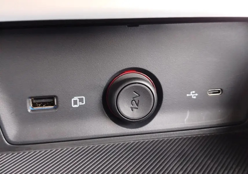 Prise 12V entourée de LED rouge avec ports USB-A et USB-C sur tableau de bord du MG ZS 1.5 L Hybrid+ Hampstead Grey.
