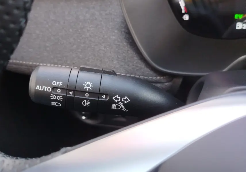Gros plan sur la manette de commande des phares et clignotants à gauche du volant dans l'habitacle du MG ZS Hampstead Grey 2026.