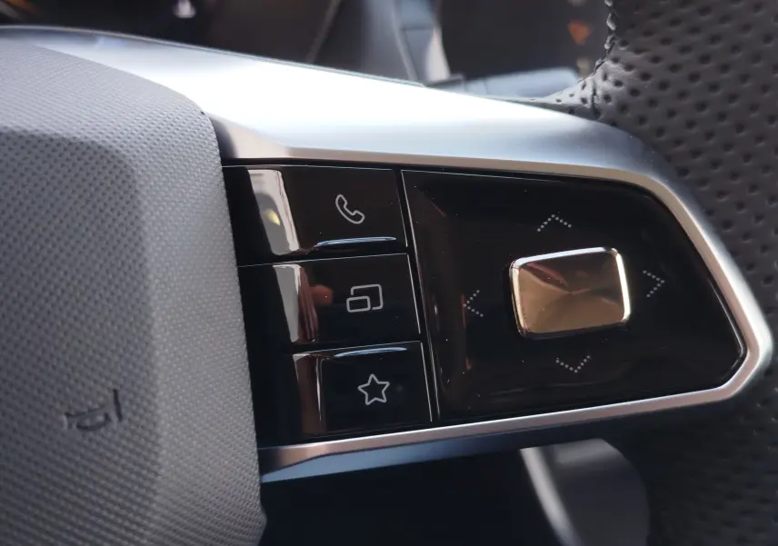 Gros plan sur les commandes multifonctions à droite du volant perforé du MG ZS 2026 en Hampstead Grey.