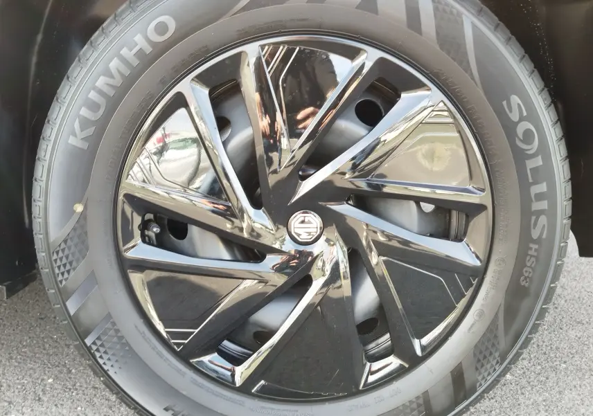 Gros plan sur la jante noire brillante du MG ZS 2026 avec logo MG au centre et pneu Kumho visible.