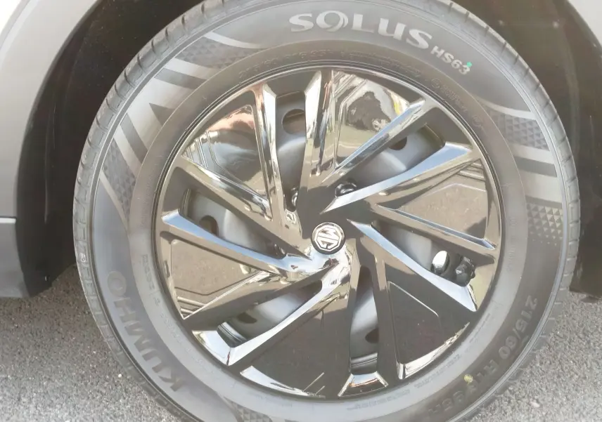 Gros plan sur la jante noire brillante et le pneu Kumho d’un MG ZS 1.5 L Hybrid+ 2026 couleur Hampstead Grey.