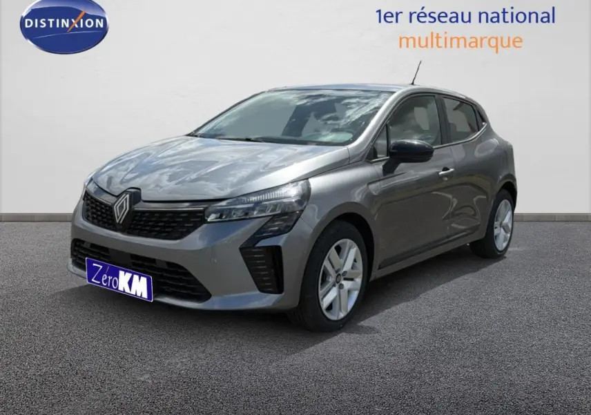Renault Clio gris foncé vue 3/4 avant droit, avec calandre noire et jantes argentées sur sol gris.