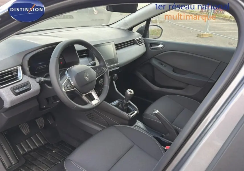 Vue intérieure côté conducteur de la Renault Clio gris foncé 2026 avec tableau de bord moderne et boîte manuelle.
