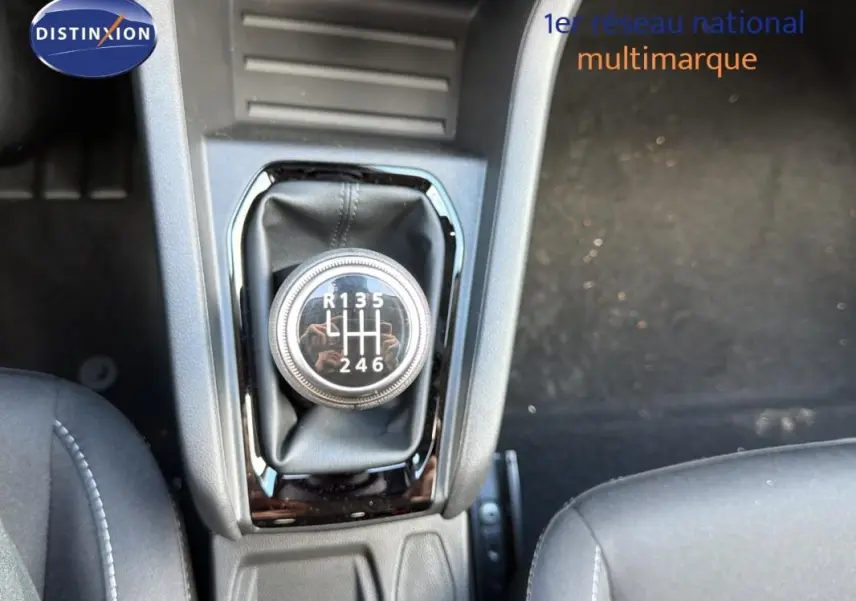 Gros plan sur le levier de vitesse manuel de la Renault Clio gris foncé, intérieur avec sièges tissu noirs.