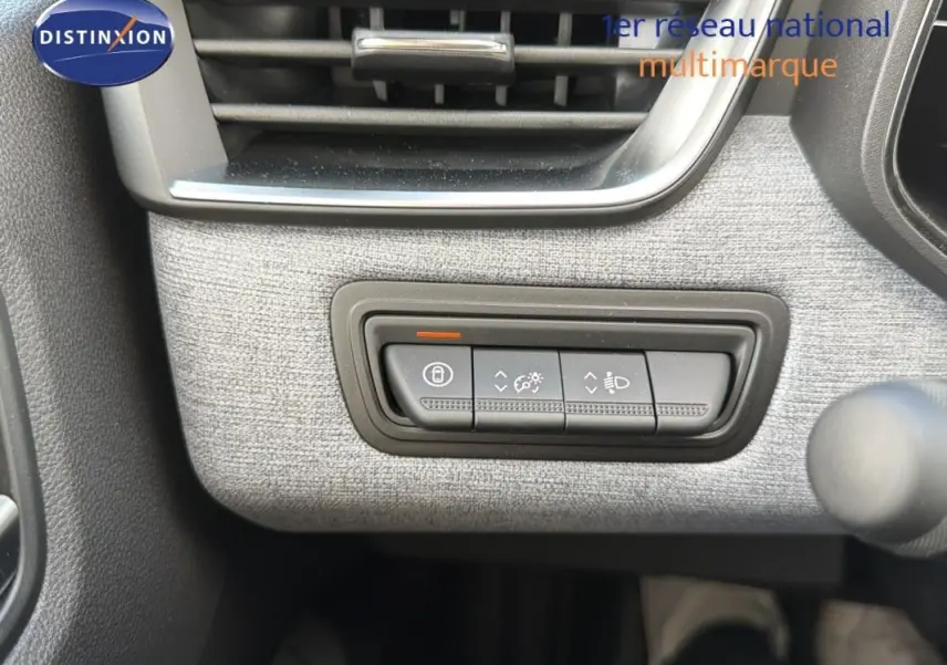 Détail du tableau de bord gris clair de la Renault Clio 2026 avec commandes d’éclairage et verrouillage.