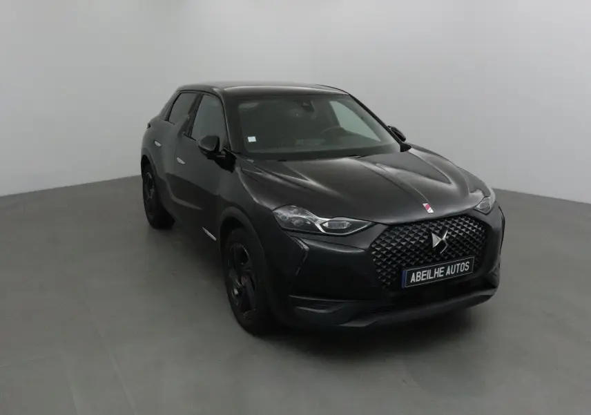 DS3 Crossback noir en 3/4 avant droit, avec calandre distinctive et phares LED DS Vision allumés.