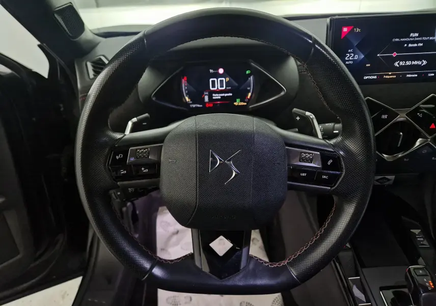 Vue rapprochée du volant en cuir noir du DS3 Crossback 2019 avec commandes intégrées et tableau de bord numérique.