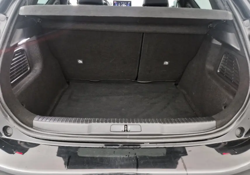 Coffre ouvert vu de l'arrière d'un DS3 Crossback noir, montrant un espace de chargement propre et bien fini.