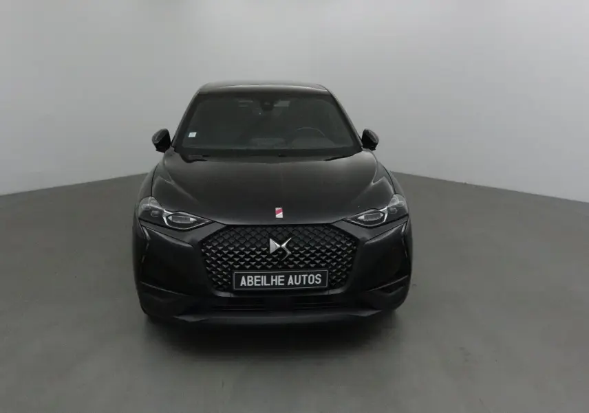 Vue frontale d'un DS3 Crossback noir avec calandre distinctive et projecteurs DS LED Vision dans un studio neutre.