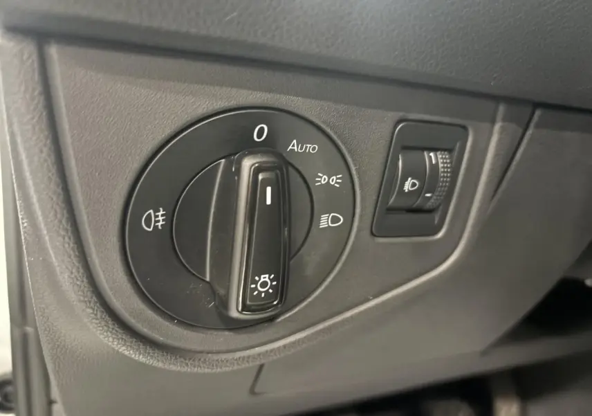 Gros plan sur le sélecteur de feux noir dans l'habitacle du Volkswagen Taigo blanc, version 2023.
