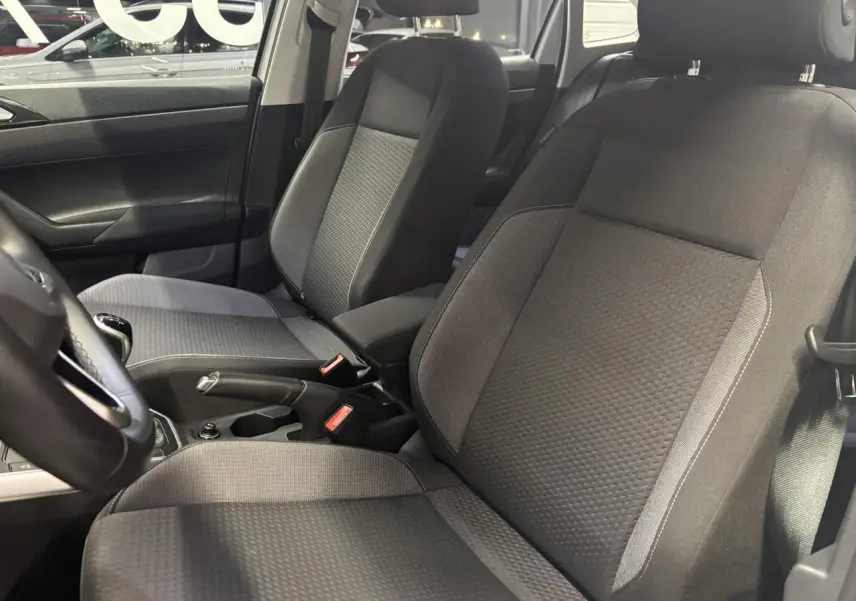 Vue intérieure côté gauche montrant les sièges avant en tissu gris du Volkswagen Taigo 1.0 TSI Life 2023.