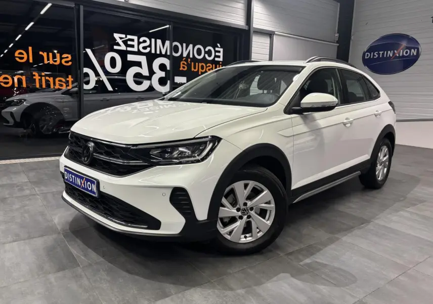 Volkswagen Taigo blanc en 3/4 avant droit, avec jantes alliage et calandre noire dans un showroom.